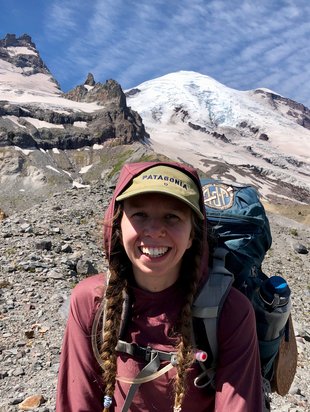 A very happy backpacker with a sunny Mount Rainier in the background