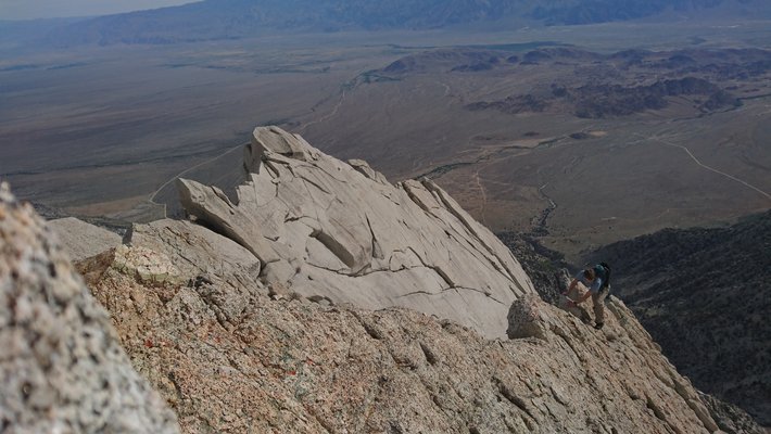 View of the maountain ridge and a climber coming up. The valley is in the background.