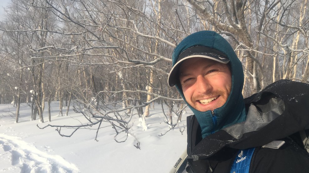 Ben geared up in front of leafless trees.