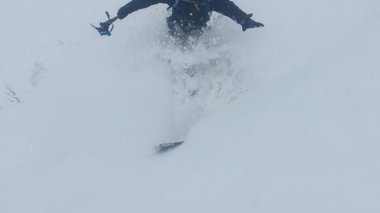 Ben skiing down in deep snow.