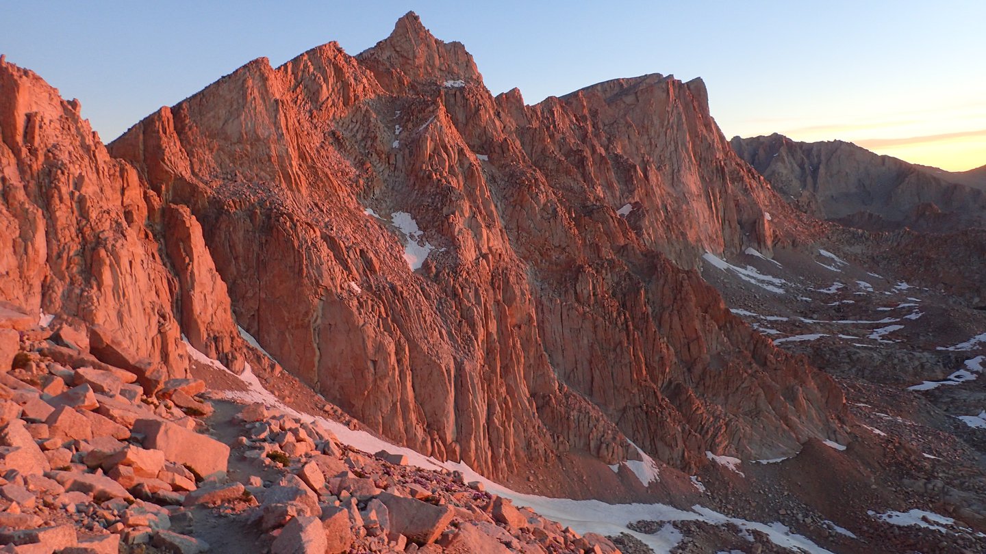 Rocky peaks in pink sunrise light. Mount Whitney is in the background