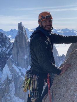 A man standing on a rock with with mountains in the background