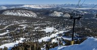 View of a part of the Mammoth Mountain Ski Resort. Skiing slopes are in the foreground, and the view fades into the Owens Valley further away.