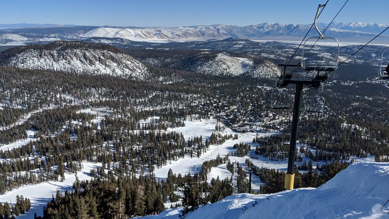View of a part of the Mammoth Mountain Ski Resort. Skiing slopes are in the foreground, and the view fades into the Owens Valley further away.