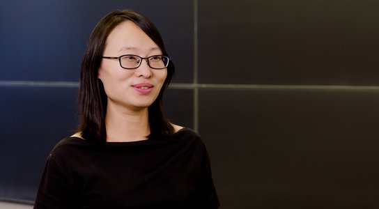 woman in black shirt and glasses smiles during an interview