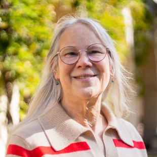 portrait of a woman with glasses wearing a sweater with red stripes