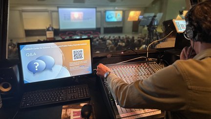 AV booth with audio operator at back of auditorium