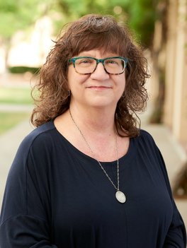 portrait of woman with brown hair and glasses