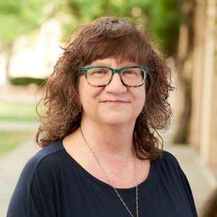 portrait of woman with brown hair and glasses