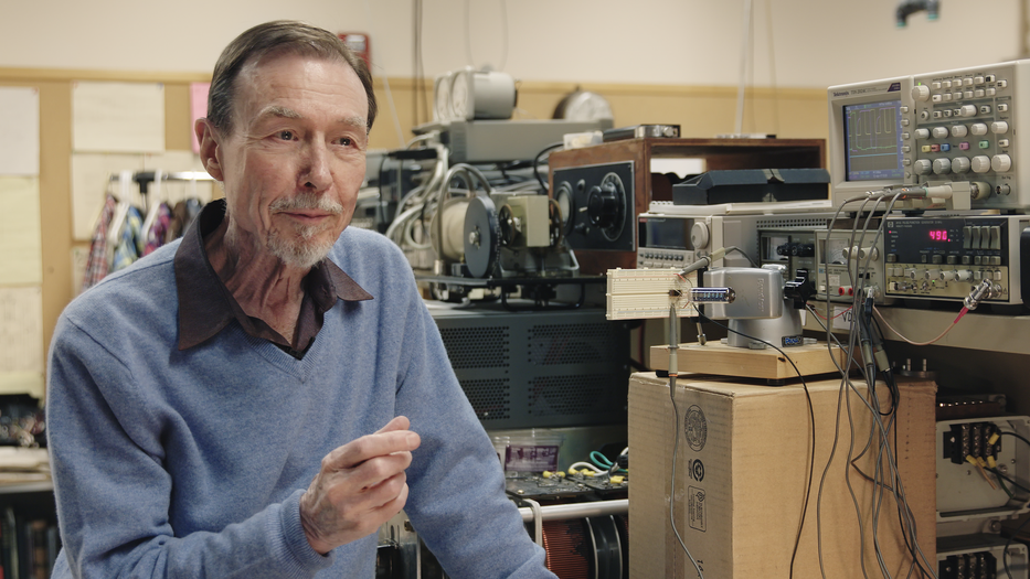 Carver Mead in his Caltech lab. The white rectangle to the right of Mead is his 1971 chip.