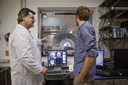two men standing at computer
