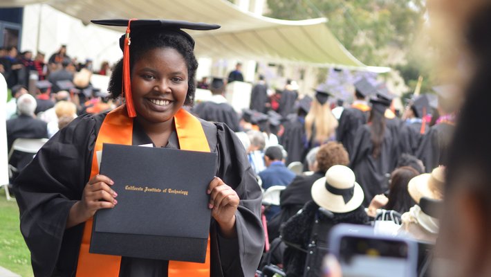 proud graduate displaying her diploma