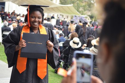proud graduate displaying her diploma