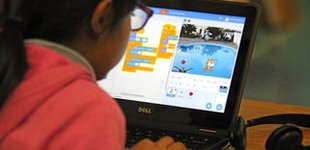 Student using Scratch application on laptop computer.