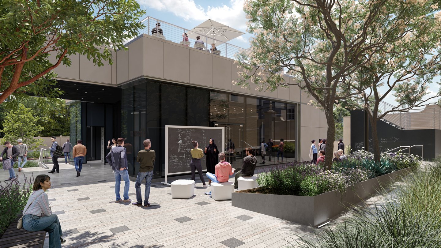 Garden with people. One-story building behind has shade umbrellas on the roof.