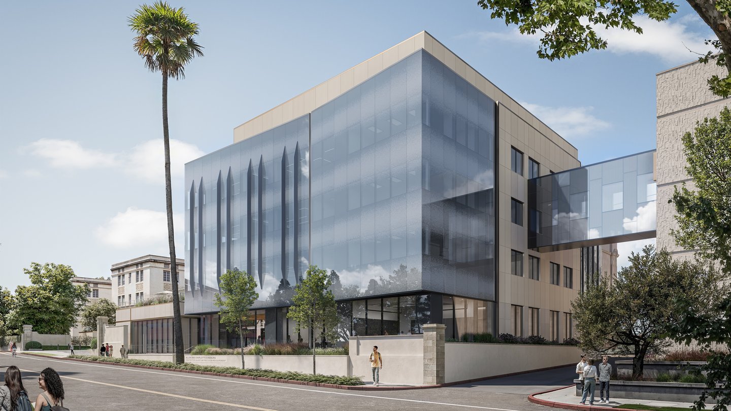 glass building with glass bridge seen across a street. There is a patio on the left side of the building.