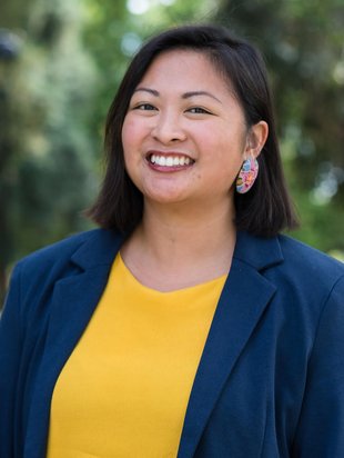 person who identifies as a women smiling. person has on a blue blazer