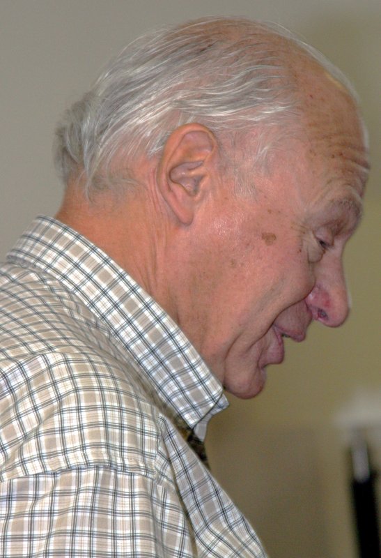 Profile of John Stachel, wearing light plaid collared shirt, looking downward. Photo taken 2002.