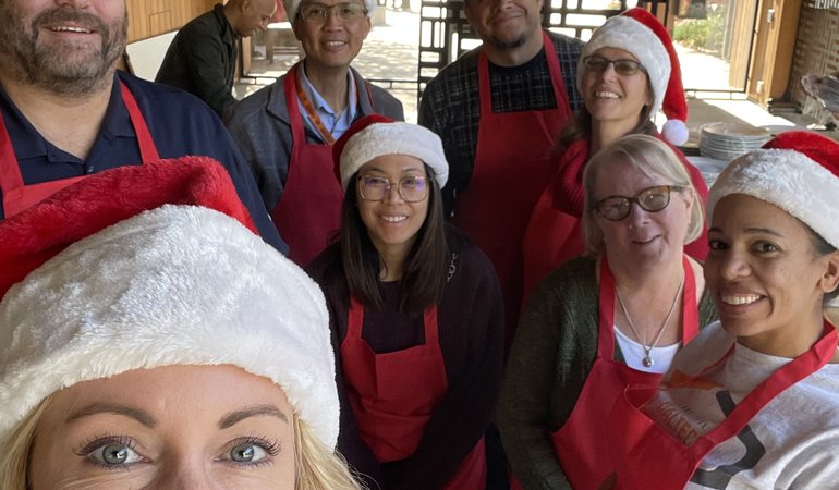 group of people wearing red santa hats and red aprons