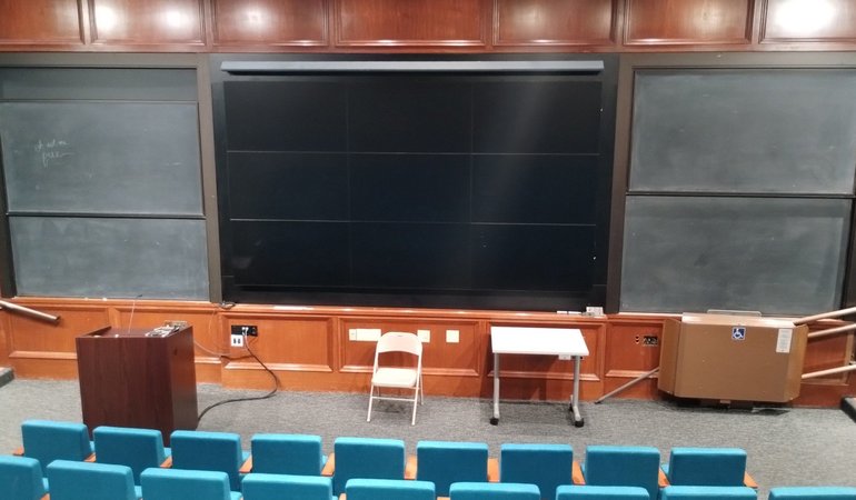 The Beckman Institute Auditorium is a lecture hall featuring oak paneling and chalkboards.