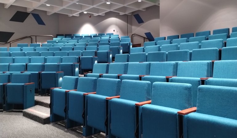 The Beckman Institute auditorium is a modern lecture hall with stadium-style seating.