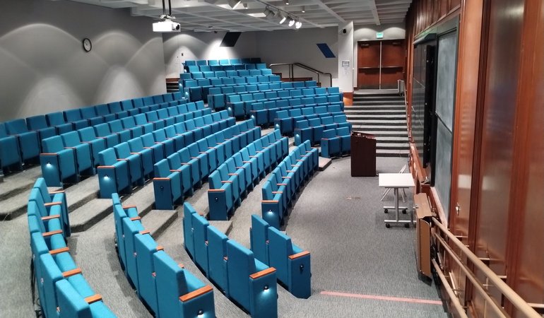 The Beckman Institute auditorium is a modern lecture hall with stadium-style seating