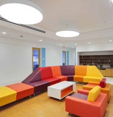 A modern lounge with geometric furniture of brightly colored upholstery