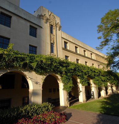 The exterior of a building with archways and plants
