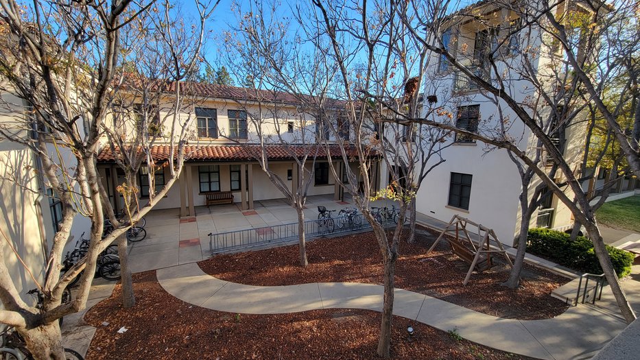 view of the Avery Interior Courtyard with two-person swing, bike racks lining the pathway, and a sidewalk path through the mulch