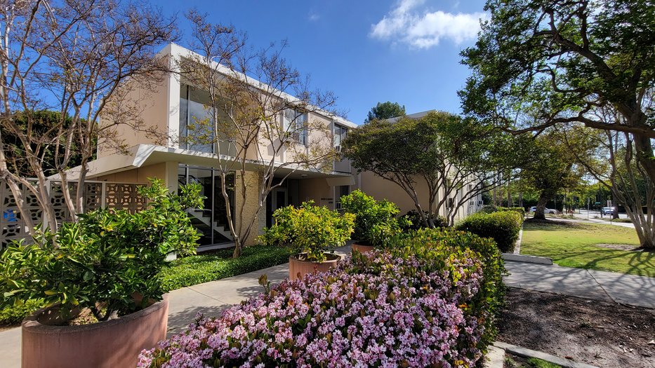 view of Marks House main entrance beside blooming, purple lantana flowers