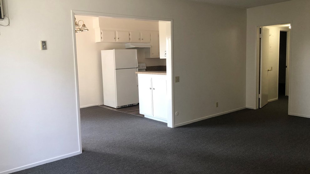 Empty family room with view of kitchen.