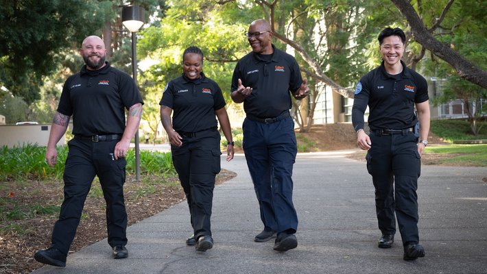 A group of four security officers walking on campus