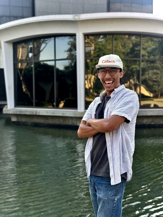 Portrait of Isaac smiling in front of a pool