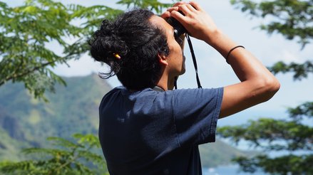 Isaac looking out of a pair of binoculars