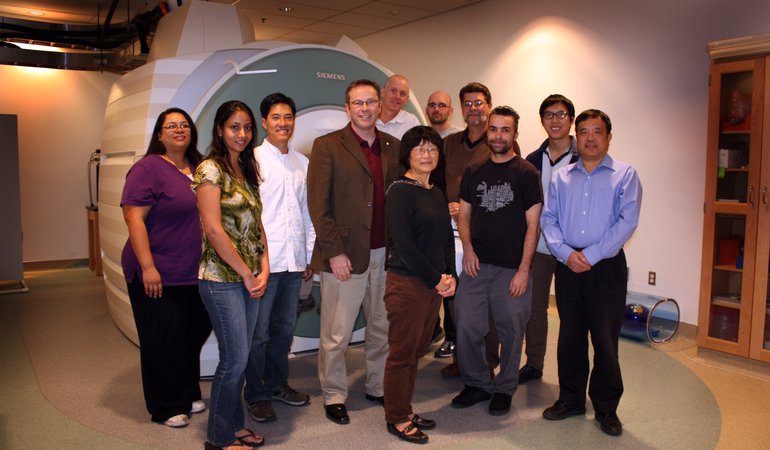 CBIC staff photograph in front of scanner