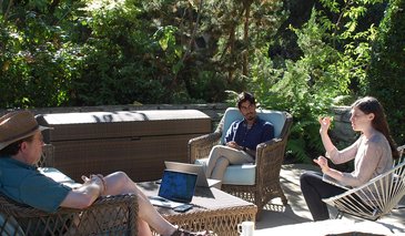 Davide Anderson (left), Adi Nair (center) and Ann Kennedy (right) sitting on a shaded patio