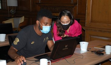 Thomas Henning (left) and Sabera Talukder (right) looking at a computer inside a classroom