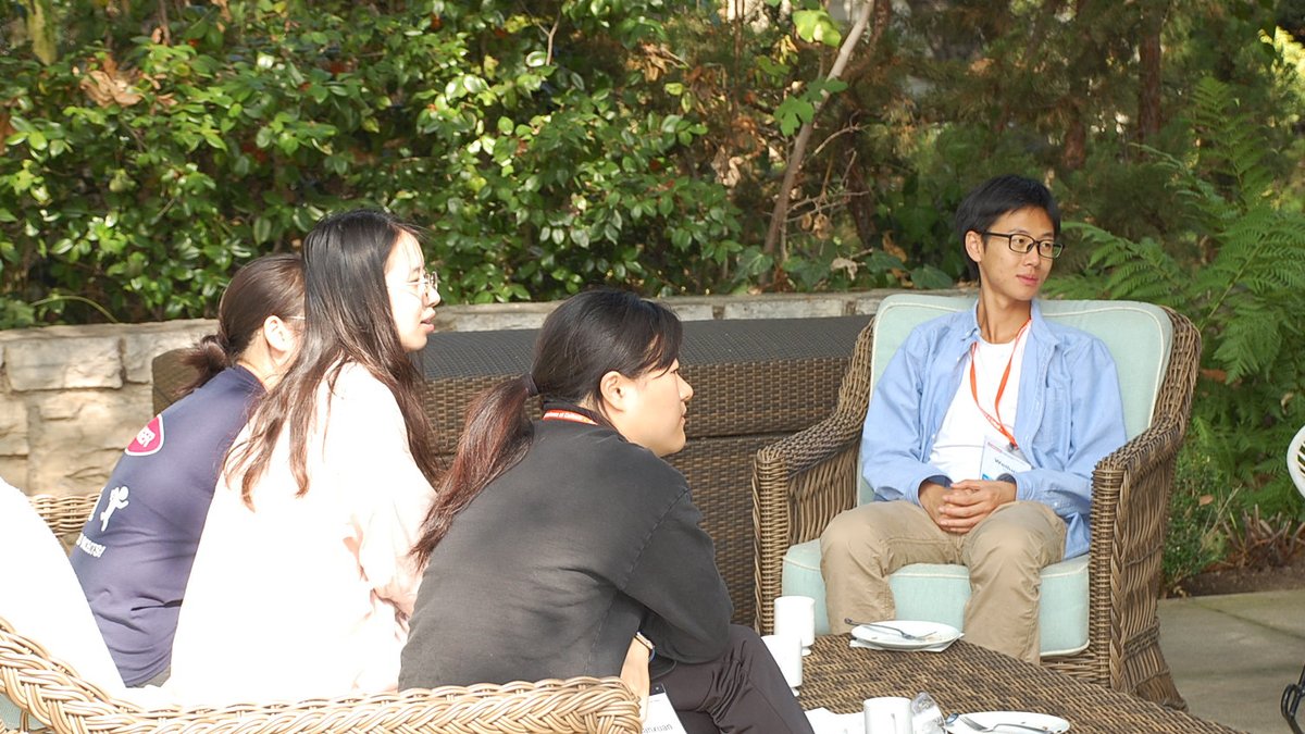 DataSAI Summer School Students sitting on wicker furniture on a garden patio