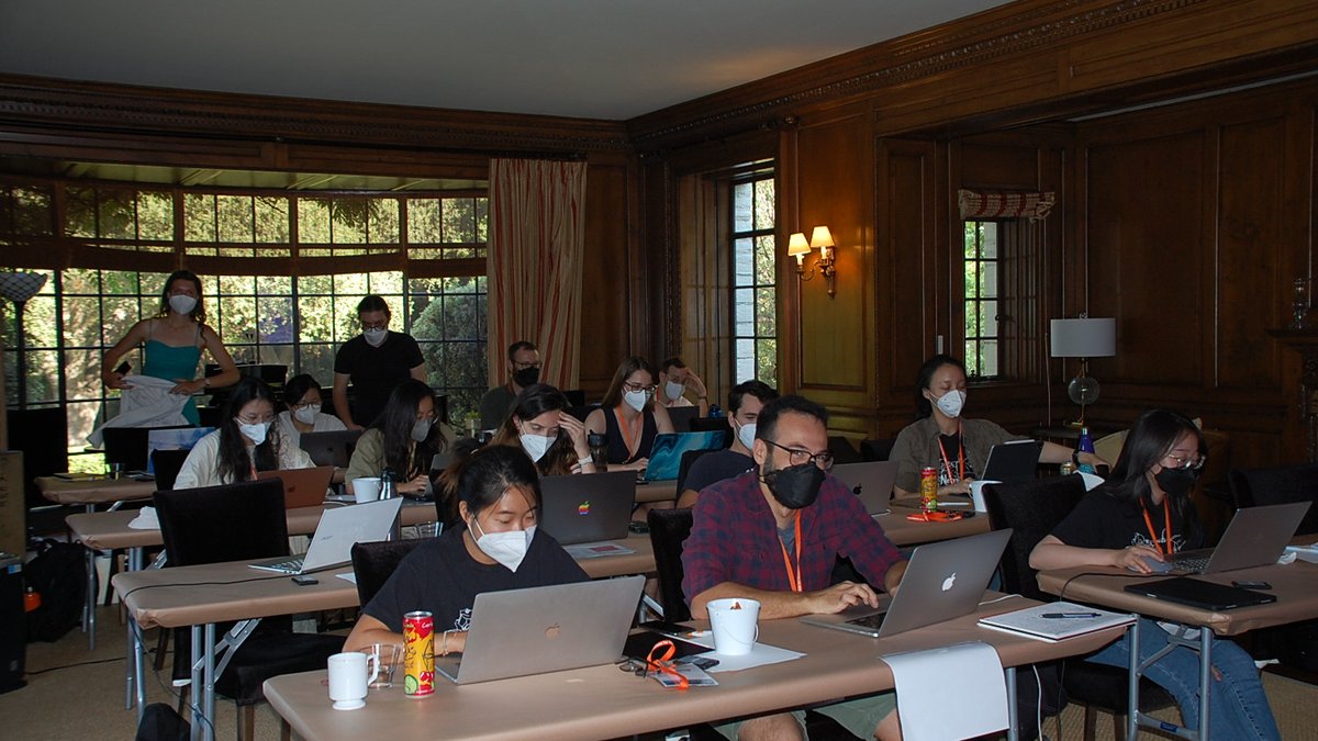 DataSAI Summer School students working in a wood paneled classroom