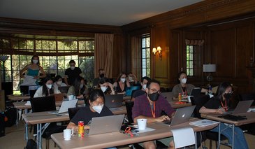 DataSAI Summer School students working in a wood paneled classroom