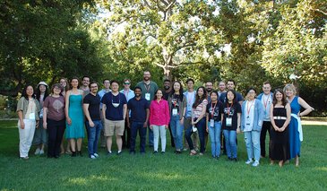 DataSAI Summer School Students and organizers standing in on grass in a garden