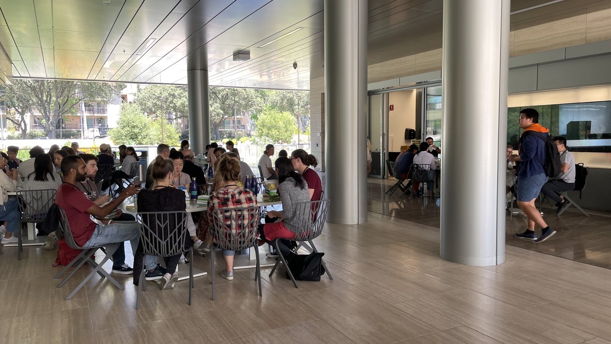 People sitting at tables eating in a breezeway area