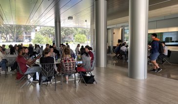 People sitting at tables eating in a breezeway area