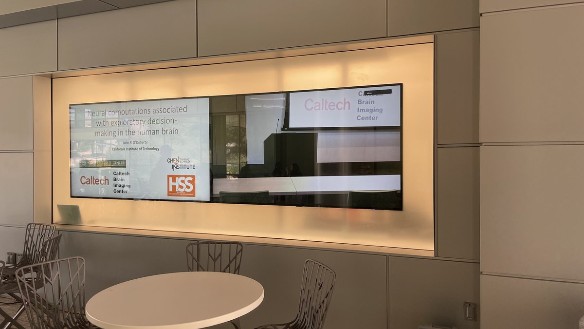 2 flat screens showing an image of a lecture podium and the title slide of a talk.