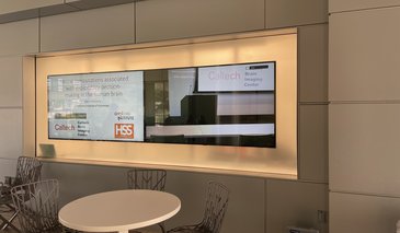 2 flat screens showing an image of a lecture podium and the title slide of a talk.