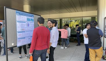 Students looking at posters on poster boards outside