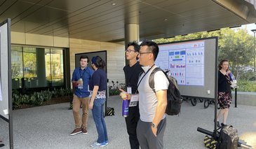 Students looking at posters on poster boards outside