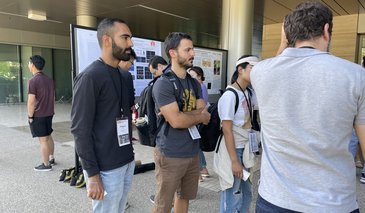 Students looking at posters on poster boards outside