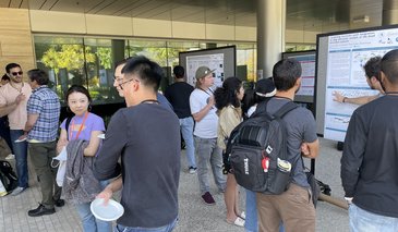 Students looking at posters on poster boards outside