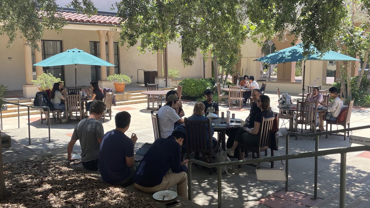 People eating outside in sunny courtyard